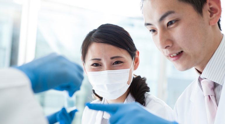 Technicians viewing a vial